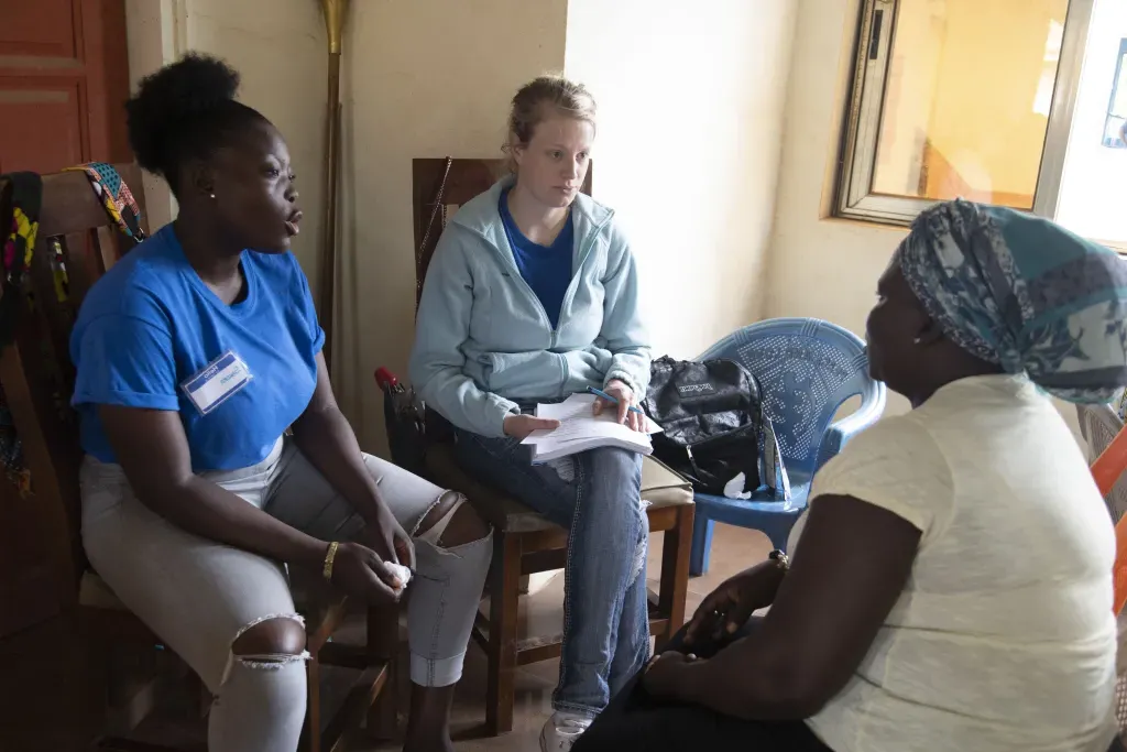 Two U N E students meet with a patient